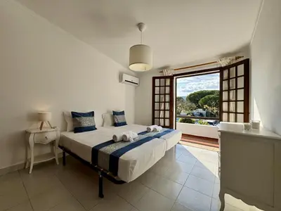 a house with a lawn with a table and an umbrella at Faro Terrace Villa by Homing in Faro