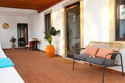a porch with a bench and a plant and a table at Monte do Couto in Albufeira