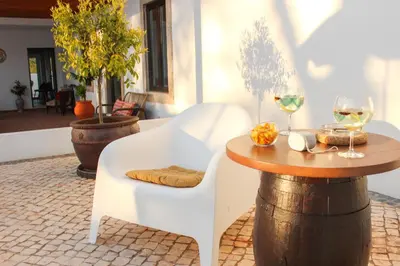 a table and chairs with wine glasses on a barrel at Monte do Couto in Albufeira