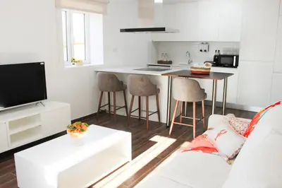 a living room with a couch and a kitchen at Monte do Couto in Albufeira
