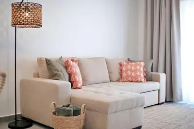 a living room with a couch and a lamp at Sea Turtle Apartment - Albufeira in Albufeira