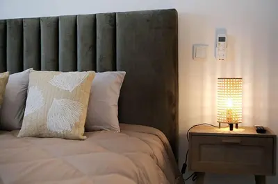 a bedroom with a bed and a lamp on a night stand at Sea Turtle Apartment - Albufeira in Albufeira
