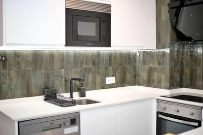 a kitchen with a sink and a microwave at Sea Turtle Apartment - Albufeira in Albufeira