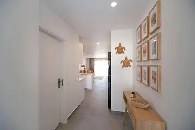 a hallway with white walls and a wooden table at Sea Turtle Apartment - Albufeira in Albufeira