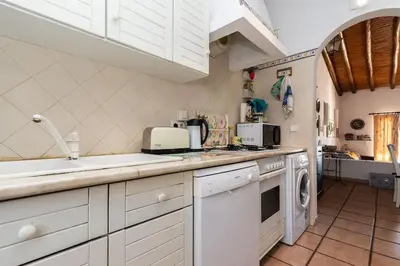 a kitchen with white cabinets and a washer and dryer at NEW! 4bedroom Villa - Private Pool and Sea view in Guia