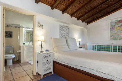 a bedroom with a large bed and a bathroom at NEW! 4bedroom Villa - Private Pool and Sea view in Guia