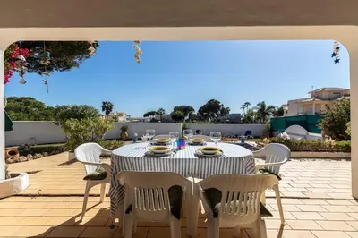 a table with white chairs and a table with glasses on it at NEW! 4bedroom Villa - Private Pool and Sea view in Guia