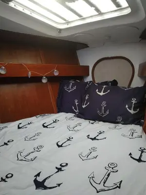 a bed in a boat with a bedspread with anchors at Houseboat - Faro in Ria Formosa in Faro