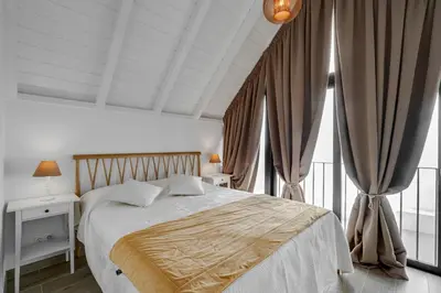 a bedroom with a large bed with curtains at Casa do Avô - Faro City in Faro