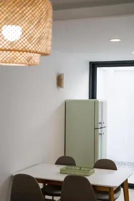 a dining room with a table and a refrigerator at Casa do Avô - Faro City in Faro