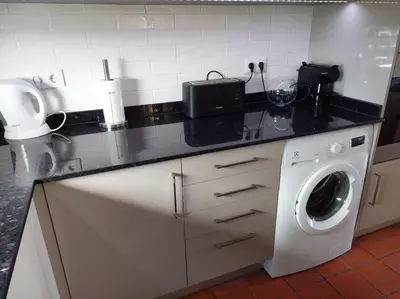 a kitchen counter with a washing machine in it at Apartamento do Moinho acesso à Piscina in Albufeira
