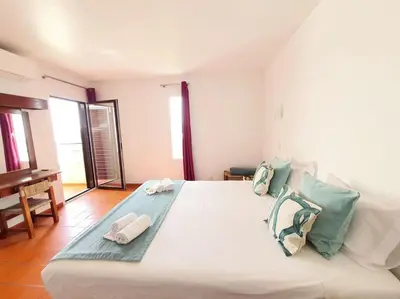 a bedroom with a large white bed with towels on it at Apartamento do Moinho acesso à Piscina in Albufeira