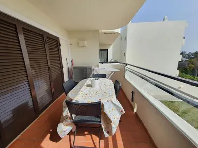 a balcony with a table and chairs on a roof at Apartamento do Moinho acesso à Piscina in Albufeira