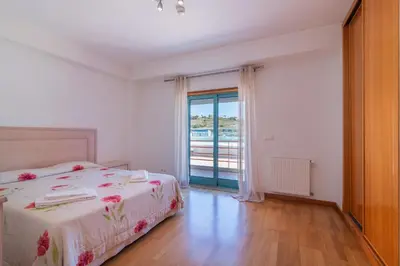 a bedroom with a bed and a large window at Marina de Albufeira by Garvetur in Albufeira