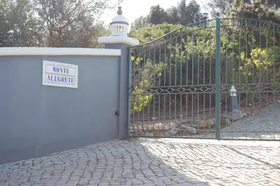 a white fence with a sign on it next to a gate at Charmante Villa mit 3 Schlafzimmer und Blick zum Meer in Santa Bárbara de Nexe
