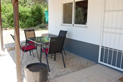 a patio with a table and chairs and a window at Charmante Villa mit 3 Schlafzimmer und Blick zum Meer in Santa Bárbara de Nexe