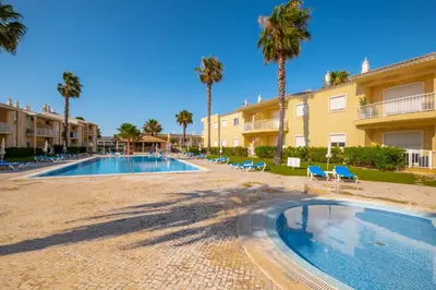 a resort with a swimming pool and palm trees at Cosy apartment in Jardins Vale de Parra in Guia