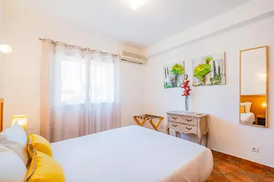 a bedroom with a white bed and a window at Cosy apartment in Jardins Vale de Parra in Guia