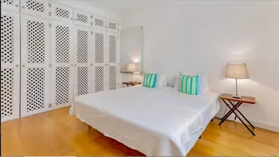 a white bedroom with a large white bed with blue pillows at Sandnblue - Encosta Do Lago Resort Club - Quinta do lago near Beach & lake BEST LOCATION in Quinta do Lago