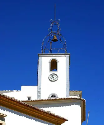 a clock tower with a bell on top of a building at Luxury 1 Bedroom Apartment, Marina de Albufeira in Albufeira