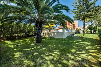 a swimming pool in a backyard with chairs and a table at 4 Bedrooms Private Pool Close To All Amenities in Quarteira