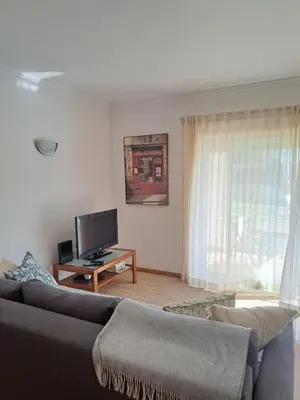a living room with a couch and a flat screen tv at Galé Garden House in Guia