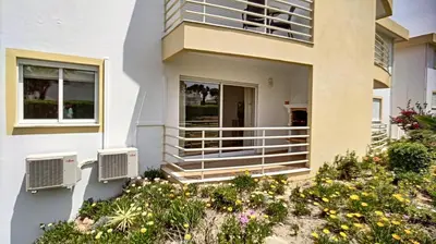 a white house with a balcony and flowers at Galé Garden House in Guia