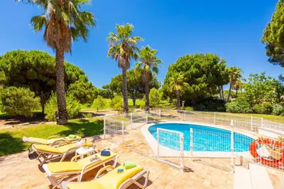 a pool with chaise lounge chairs next to a resort at Villa Mexico in Quarteira