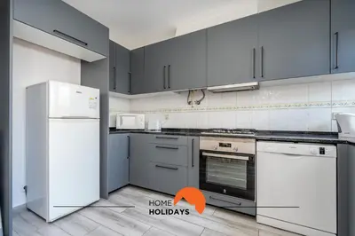 a kitchen with white appliances and an orange arrow pointing to home holidays at #229 Quinta das Areias by Home Holidays in Albufeira