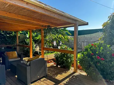 a wooden pergola sitting on a wooden deck at Casa de Aloe in Albufeira