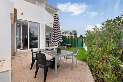 a table and chairs with a umbrella on a patio at Oura Southvilla Algarve in Albufeira