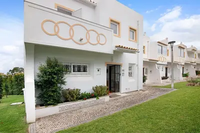 an exterior view of a white house with rings on the facade at Oura Southvilla Algarve in Albufeira