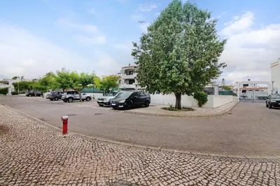 a parking lot with cars parked next to a tree at Oura Southvilla Algarve in Albufeira