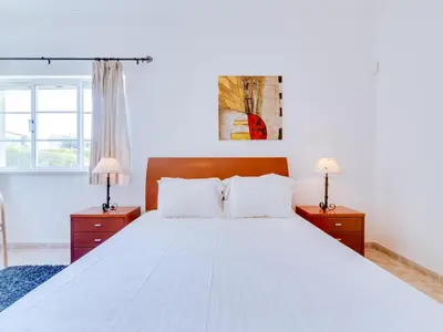 a bedroom with a large white bed with two night stands at AL Casa Raha in Quinta do Lago