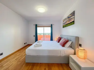 a bedroom with a large bed and a window at Fantastic Villa, Private Pool, BBQ, AC and Wi-Fi in Quarteira