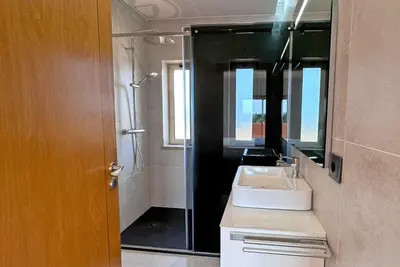 a bathroom with a sink and a shower with a mirror at Fantastic Villa, Private Pool, BBQ, AC and Wi-Fi in Quarteira