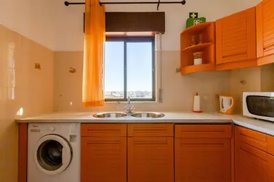 a kitchen with a sink and a washing machine at Appartement Albufeira in Albufeira