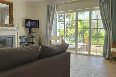 a living room with a couch and a fireplace at Private luxury apartment Vale do Lobo in Almancil