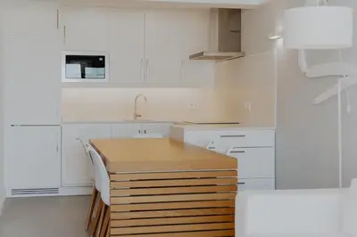 a kitchen with white cabinets and a wooden counter top at MUPA Apartments in Albufeira