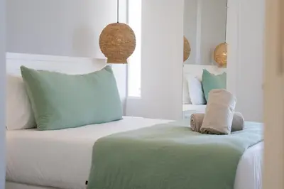 a bedroom with a bed with green and white pillows at MUPA Apartments in Albufeira