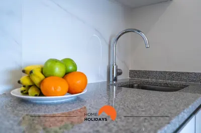 a kitchen counter with a bowl of fruit and a sink at #233 Fox Trail by Home Holidays in Albufeira