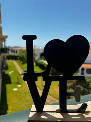 a heart statue sitting on top of a window at Albufeira Appartement avec piscine in Albufeira