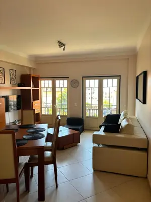 a living room with a couch and a table at Albufeira Appartement avec piscine in Albufeira