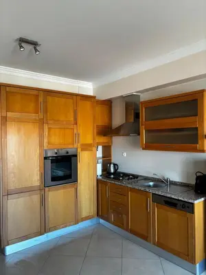 a kitchen with wooden cabinets and a stove top oven at Albufeira Appartement avec piscine in Albufeira