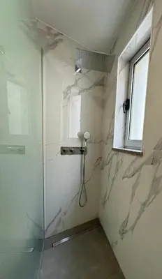 a shower with a glass door and a window at Marina Gemeos - Vilamoura Center by HD Properties in Vilamoura