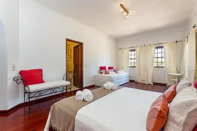 a bedroom with a bed and a chair in a room at Villa Sobreiro in Albufeira