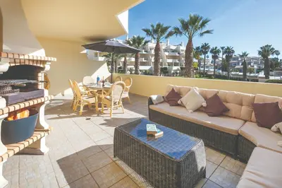 a kitchen with white cabinets and a stove top oven at Stylish 2BR Apartment with Pool Parking & WiFi in Albufeira
