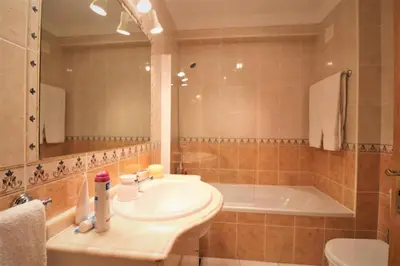 a bathroom with a sink and a bath tub at Stylish 2BR Apartment with Pool Parking & WiFi in Albufeira