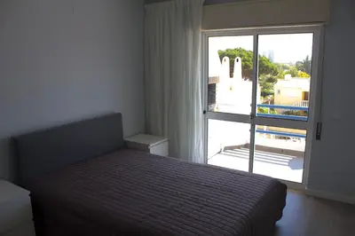 a bedroom with a bed and a large window at Vilamoura 10 in Quarteira