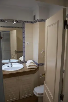 a bathroom with a sink and a toilet and a mirror at Vilamoura 10 in Quarteira